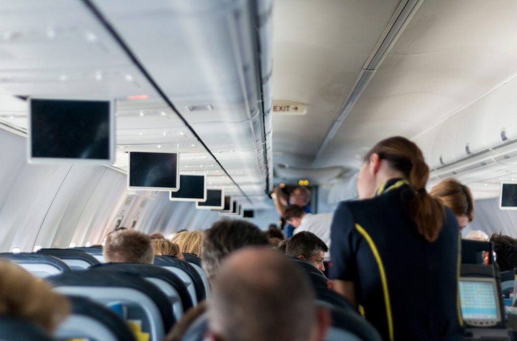Das Bild zeigt das Bordpersonal eines Flugzeuges, das die Gäste umsorgt